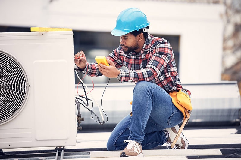 HVAC Technician working on outdoor unit.
